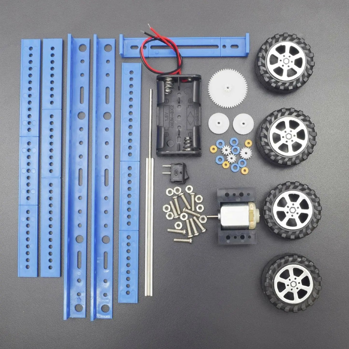 Collection of robot building components including wheels, gears, and motors on a gray background