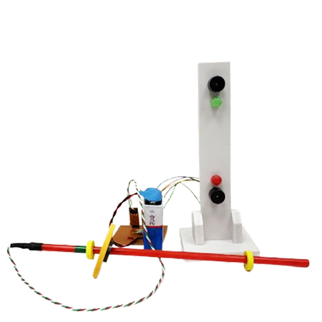 A homemade science project features a red rod with rings, connected to a small circuit board with a battery and wires—part of an inventive water level indicator. A vertical white stand with red and green buttons enhances the electronics kit setup.